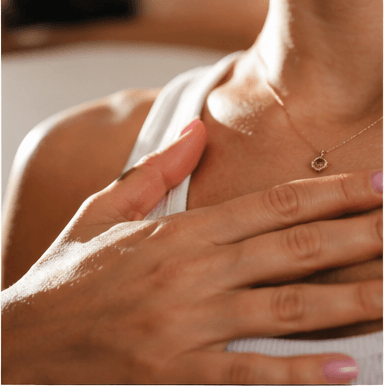A hand resting on the chest in daylight, breath visible in the rise and fall.