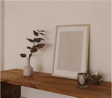A studio shelf with ceramic vessels and a small candle, lit by daylight.